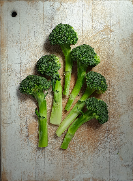 Broccoli spears on a distressed white cutting board
